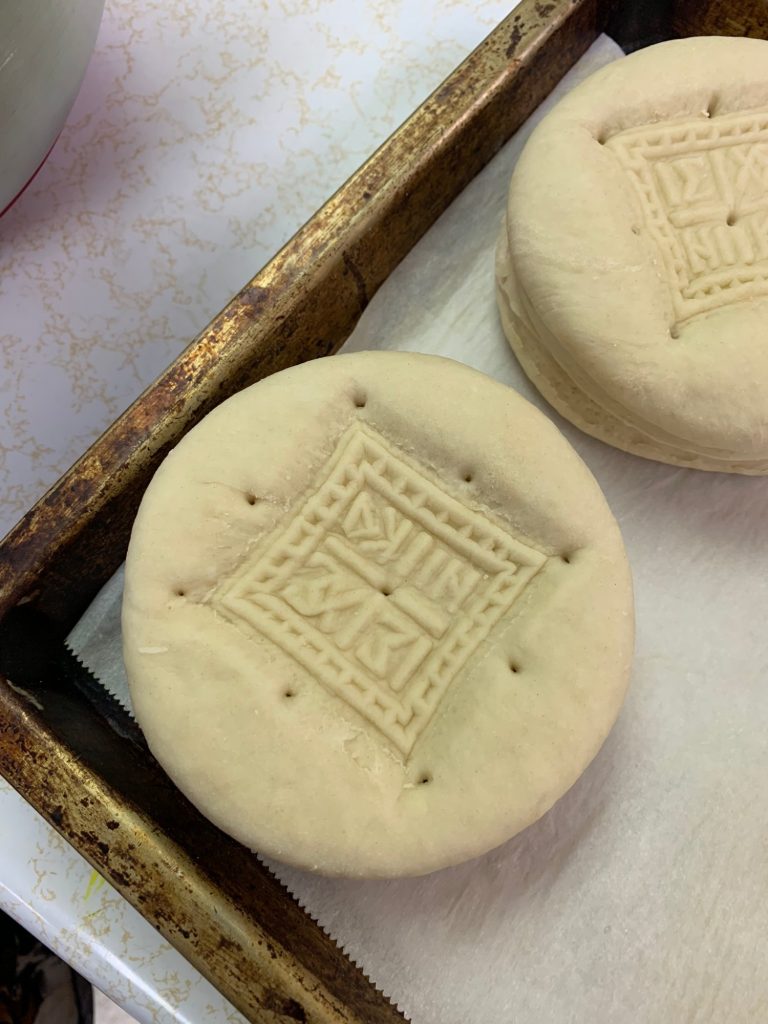 After stamping the formed loaf, a toothpick is used to poke holes around the stamp area so it does not deform when baking.