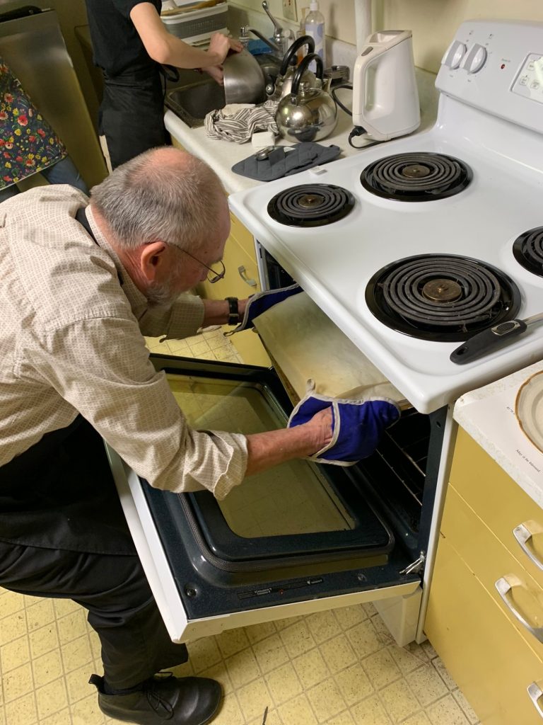 Removing the prosphora breads from the oven.