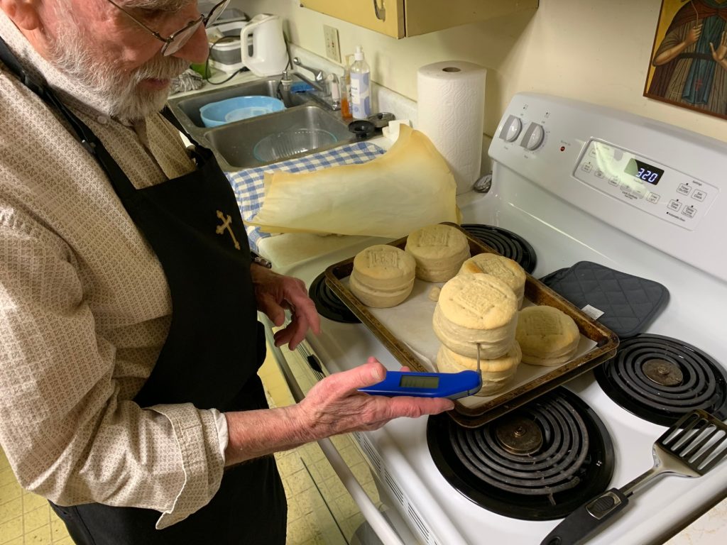 Dan C. checks the internal temperature of the prosphora to ensure it is cooked through.